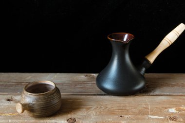 Eski bir el kahve ve siyah Türk fincanı eski ahşap masa ve siyah arka plan üzerinde