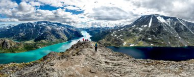 İki farklı renkte gölün arasından geçen bir grup turist. Jotunheimen Norwey