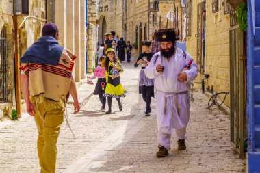 Safed, Israel - March 10, 2020: Jewish men and women in costumes, it is a tradition of Purim (Jewish Holiday). In the old city of Safed (Tzfat), Israel