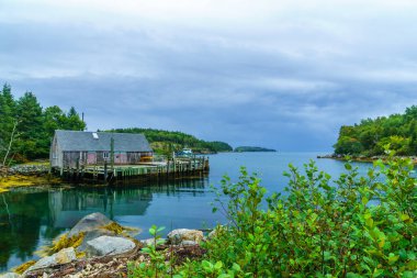 Körfezin manzarası, balıkçı köyü Aspotogan, Nova Scotia, Kanada 'daki tekneler ve rıhtım binaları