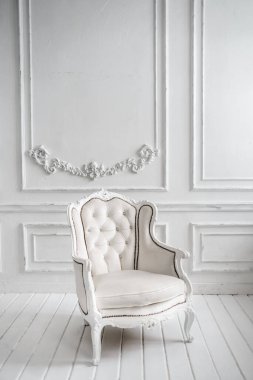 Beyaz deri koltuk. Yapay çiçekli büyük ayna..