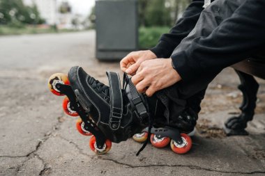 Sokakta paten kaymadan önce paten kayan bir adam var..