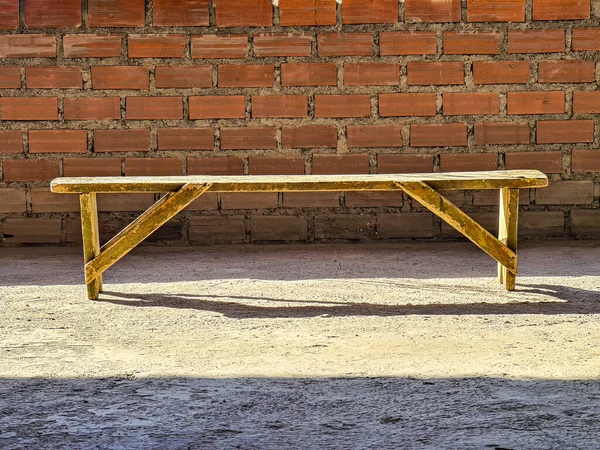 レンガ造りの背景に木製の古いベンチ孤立 — ストック写真