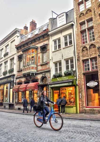 Bruges, Belçika 30-10-2014 Bisikletli genç bir kadın şehir sokaklarından birinde