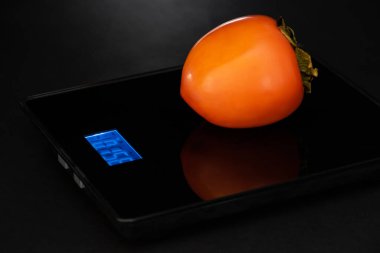 Hurma, siyah arka planda elektronik bir ağırlıkta..