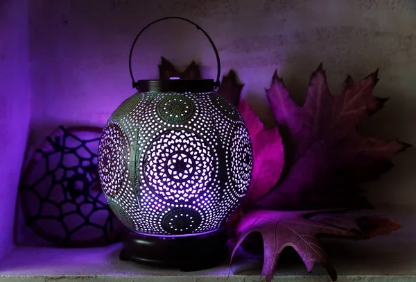 Aroma diffuser in the style of an ancient oriental lamp. Still life with a diffuser, a catcher of dreams and maple leaves.