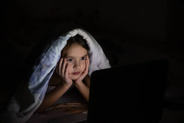 아이가 담요를 노트북을 들여다보고 있습니다 — 스톡 사진