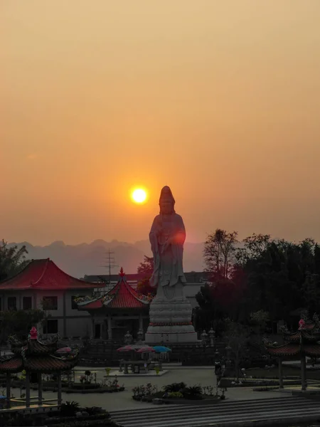 Uma estátua de budda em frente a um pôr-do-sol — Fotografia de Stock