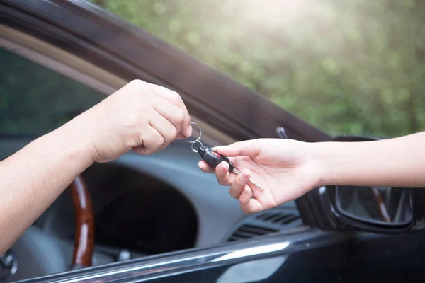 Primer plano Mano masculina que entrega las llaves del coche a la mujer . — Foto de Stock