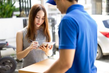 Paket alma ve imza koyarak güzel genç kadın