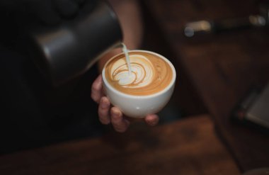 Barista süt ve kahve, w müşteri yoğunlaşmaya Latte sanat yapma