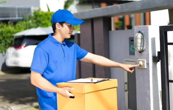 Delivery concept - Happy delivery person in blue uniform holding