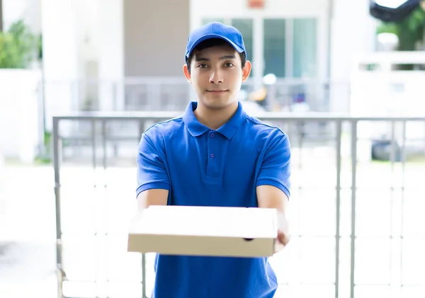 Portrait delivery person in blue uniform holding pizza box stand