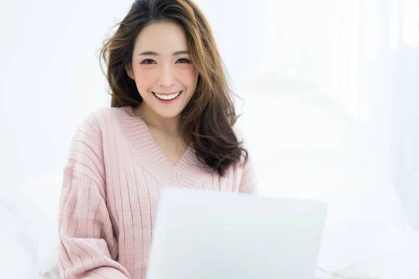 Joyeux belle femme tapant sur ordinateur portable dans la maison en hiver et son regarder la caméra. Style de vie des femmes Concept — Photo