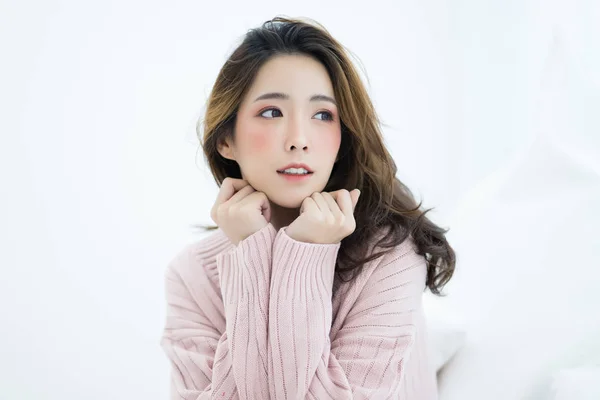 Young beautiful woman in warm knitted sweater pink cold and sitting at home. Looking at side view. Model fashion shooting. Autumn, winter season. — Stock Photo, Image