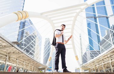 Handsome businessman using mobile phone and looking away while s