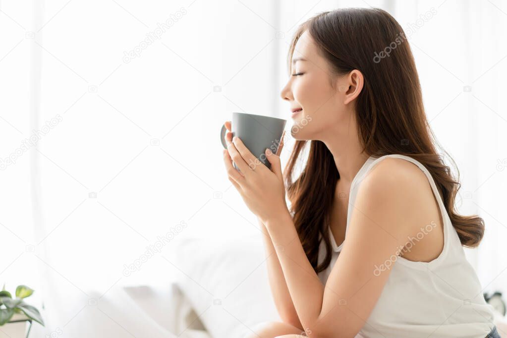 Happy smiling beautiful Asian woman enjoying first morning and s