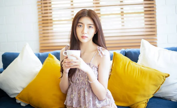 Belle jeune femme asiatique relaxante sur canapé avec café et toilettes — Photo