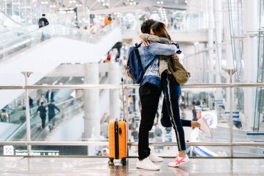 Havaalanı terminalinde sarılan Asyalı genç bir çiftin portresi.. 