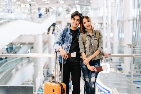 Heureux jeune couple asiatique debout tenant passeports et à la recherche — Photo