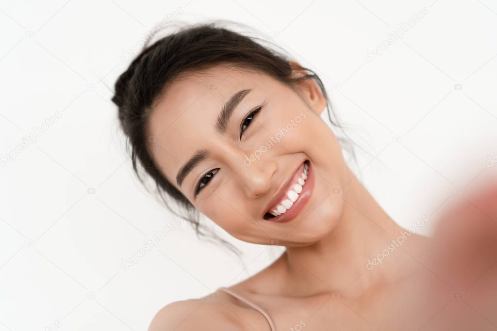 Closeup portrait of beautiful young Asian smilling with white te
