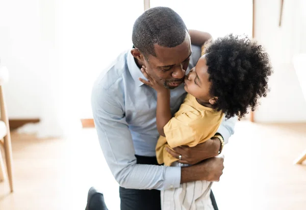 幸せな小さなアフリカ系アメリカ人の少年抱擁し お父さんはリビングルームで自宅で仕事の後に彼に会うために興奮キス お帰りなさいパパや家族の再会のコンセプト — ストック写真
