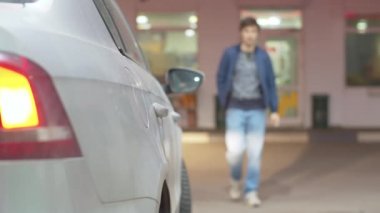 Arabaya yakıt dolduran bir adam.