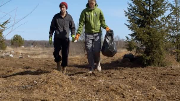 Ormanın yakınında çöp torbası taşıyan çevre gönüllüleri. — Stok video