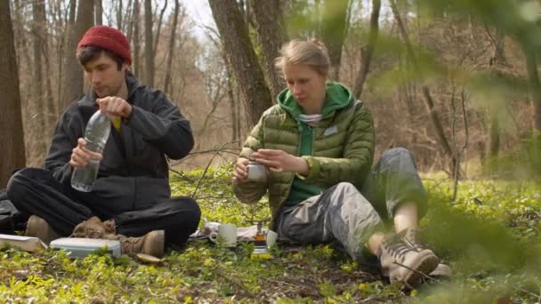 Молода сім'я в лісі робить каву — стокове відео