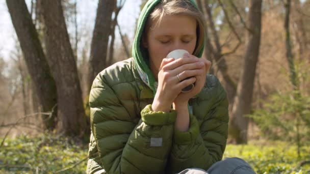 Женщина пьет кофе в лесу — стоковое видео
