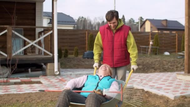 Uomo spingendo la sua mamma in una carriola — Video Stock