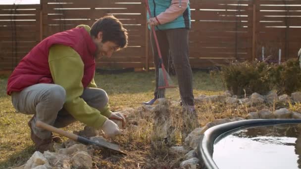 Family prepares flowerbed for spring planting — Stock Video