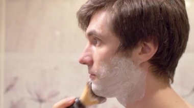 Adam köpük sürüp tıraş oluyor.