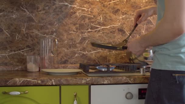 L'uomo prova a capovolgere una frittella fritta — Video Stock