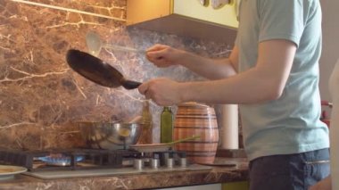 Genç adam krep kızartıyor.