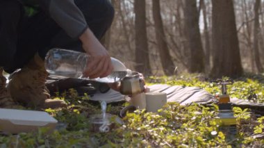 Ormanda kahve yapan genç adam.