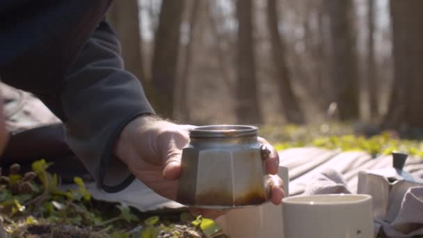 Jongeman in het bos die koffie maakt — Stockvideo