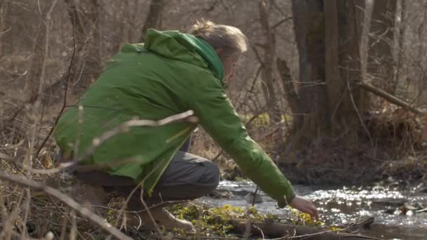 Giovane donna seduta sulla riva del fiume — Video Stock