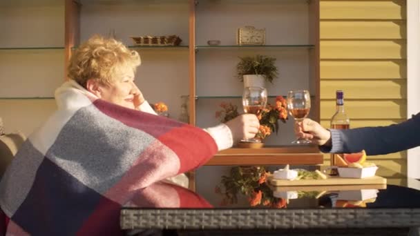 시니어 여자와 젊은 남자가 와인 잔을 연다 — 비디오