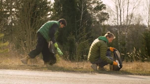 Fiatal Pár Öko Önkéntesek Gyűjtenek Szemetet Erdőben Tavasszal Zöld Tűlevelű — Stock videók