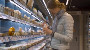 Süpermarkette yiyecek seçen bir kadın.