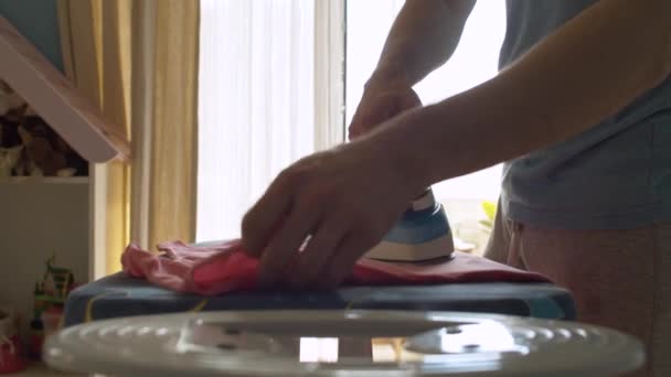 Руки молодого человека гладильная одежда — стоковое видео