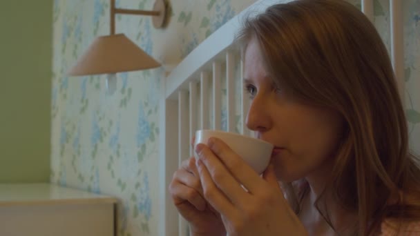Молодая женщина пьет кофе в плохой — стоковое видео