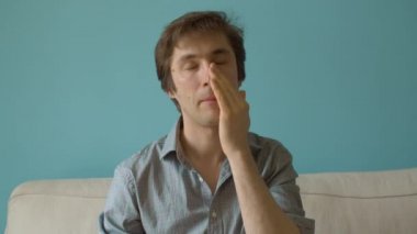 Genç adam yüzüne krem sürüyor.