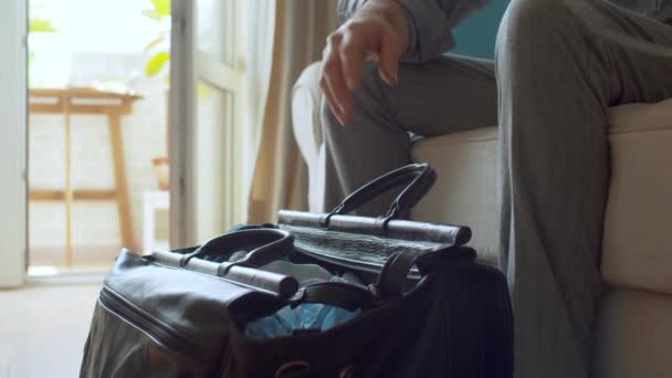 Χέρια ενός άντρα που πακετάρει ταξιδιωτική τσάντα, διαζύγιο — Αρχείο Βίντεο