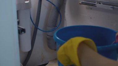 Kadın elleri mevcut sifonun altına kova koyuyor