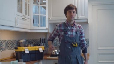 Mutfaktaki mutlu tesisatçı portresi.