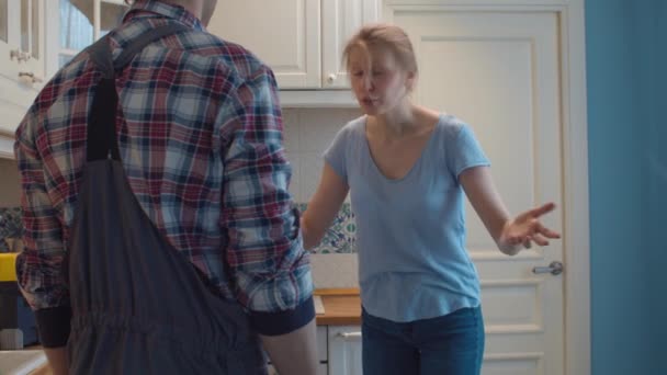 Rörmokare och ung kvinna i köket — Stockvideo