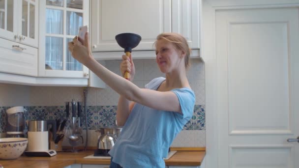 Жінка з плунжером в руках бере селфі — стокове відео