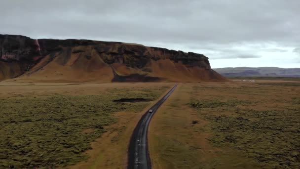 緑の苔の溶岩畑に囲まれた未舗装の道路を車で運転する空中4Kビュー アイスランド ヨーロッパ ドローン三脚ショット — ストック動画